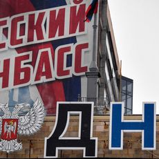 Cette photographie prise à Donetsk le 18 janvier 2022 montre l'emblème de la République populaire autoproclamée de Donetsk (RPD) affiché sur le bâtiment du Conseil du peuple et un slogan indiquant "Donbass russe".