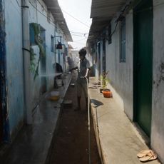 Un membre de l'équipe sanitaire diffuse du désinfectant sur les murs de la ville