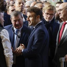 Le président français Emmanuel Macron, entouré du ministre français de l'Agriculture Marc Fesneau, s'entretient avec un éleveur français au Salon de l'agriculture, le jour de l'inauguration de la 59e édition à Paris le 25 février 2023. 
