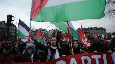 Des manifestants tiennent une bannière et brandissent des drapeaux palestiniens lors d'une manifestation de soutien aux Palestiniens à Paris, le 9 décembre 2023.  