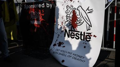 Des banderoles contre le géant alimentaire suisse Nestlé ont été vues lors d'une manifestation contre l'invasion russe de l'Ukraine à côté du Parlement suisse à Berne, le 19 mars 2022.