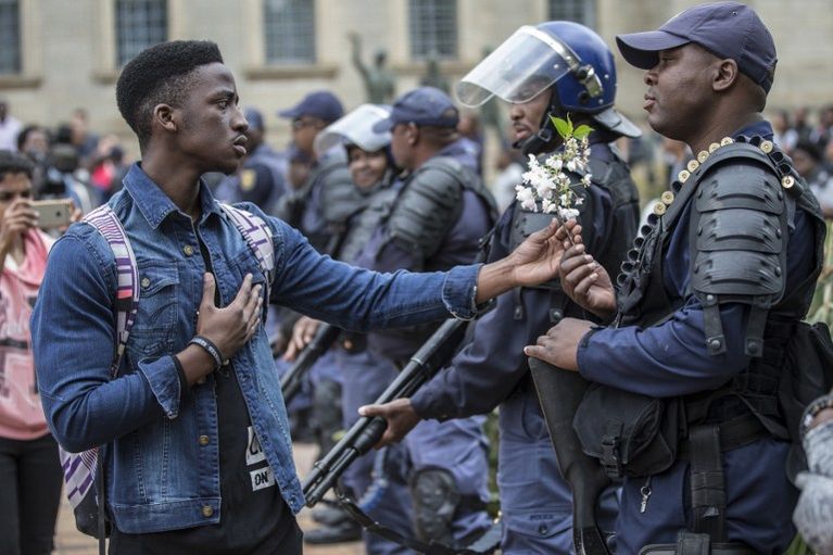 Un étudiant offre une gerbe à un policier, ce mardi à Johannesburg. 
